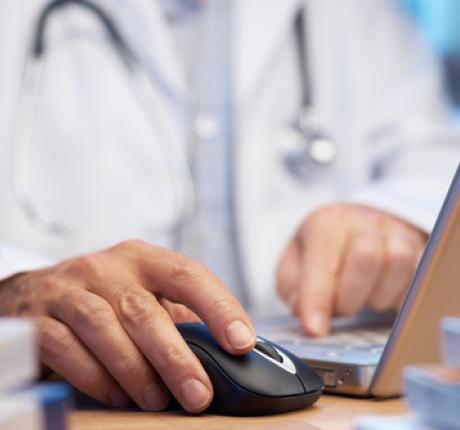 Dokter werkend op computer